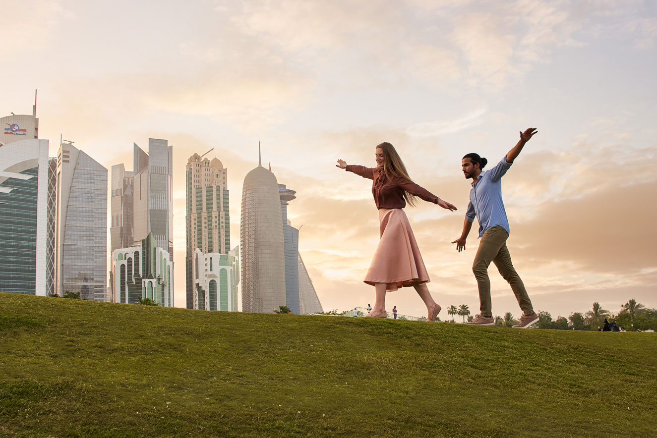 a playful couple posing in front of buildings